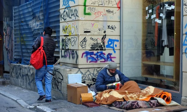 A homeless man sits on the pavement near Syntagma Square in Athens.
