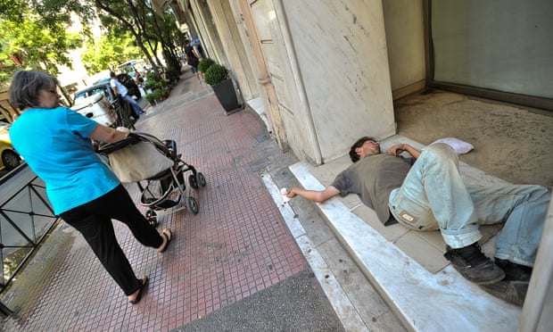 A homeless man sleeps in front of a shop in Athens.