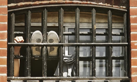 A prisoner holds his hand up at the window of a cell at  Norwich Prison