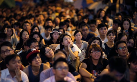 Pro-democracy protesters watch talks between student protest leaders and officials on a screen