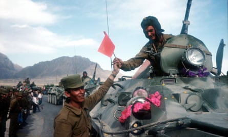 A Soviet soldier is handed a flag as Soviet troops withdraw from Afghanistan in 1988 after an agreement with the US.