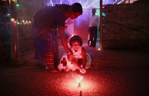 Gauhati, India Helping a child to light a firecracker