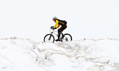 A cyclist tackles a snowy track in Derbyshire.