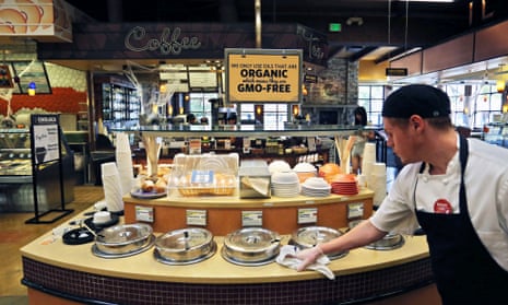A grocery store employee wipes down a soup bar with a display informing customers of organic, GMO-free oils, in Boulder, Colorado, Oct. 23, 2014. 