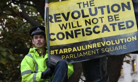 An Occupy Democracy protester climbs on the statue of Winston Churchill as police clear Parliament Square.