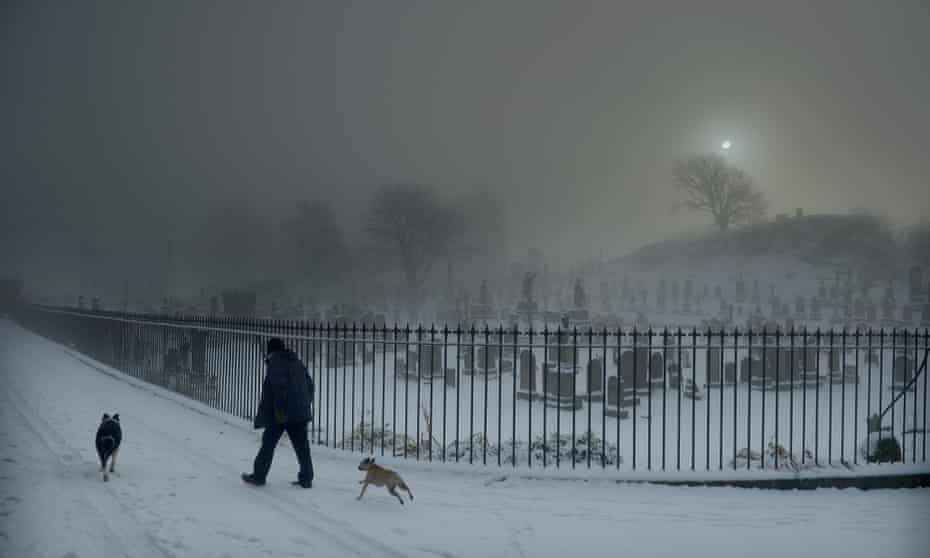 A man walks his two dogs past Stirling Castle graveyard on December 3, 2012 in Stirling, Scotland. Snow and sleet has hit many parts of Scotland with heavier falls expected over higher grounds.
