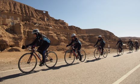 The Afghan Women's National Cycling Team passes mud dwellings on the highway through the mountains of Afghanistan's Bamiyan Province.