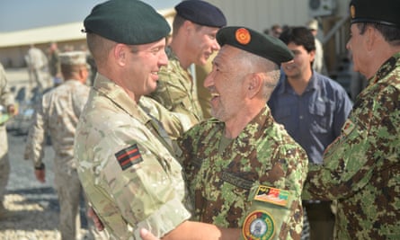 British and Afghan soldiers embracing each other during the handover ceremony of Camp Bastion in Afghanistan.