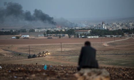A man watches US air strikes aimed at Isis forces from a hill in Sanliurfa province of Turkey