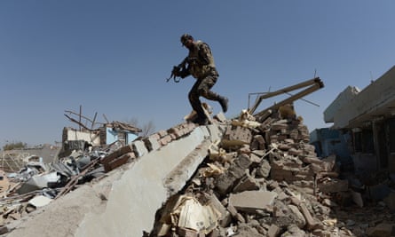 The Taliban is gathering strength across Afghanistan: here an Afghan soldier walks over rubble at the scene of a suicide attack on a government compound in Ghazni.