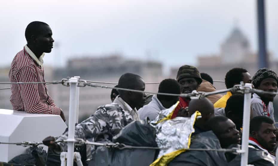 Rescued migrants wait to disembark in Palermo, Italy