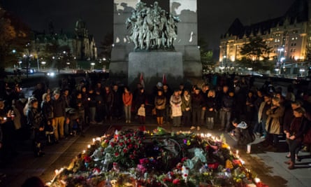 The Tomb of the Unknown Soldier at the National War Memorial is surrounded by people during a candlelight vigil in Ottawa.