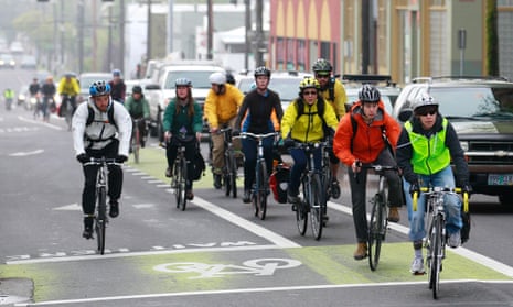 Bike commuters travel down along a street, in Portland, Oregon