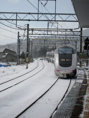 Akita Shinkansen arriving at a snowy Tazawako Station.