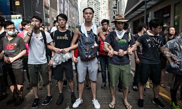 Pro-democracy protesters link arms to protect a barricade from counter-demonstrators in Hong Kong