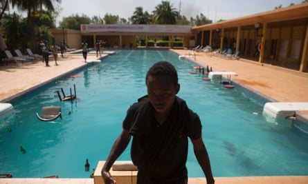 A protester stands in front of a hotel pool, where members of the parliament were said to be staying in Ouagadougou, October 30, 2014.