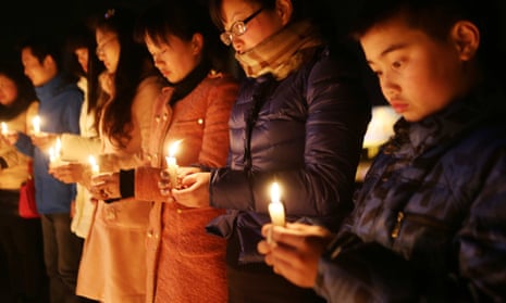 people hold candles at a vigil for victims of the kunming mass stabbing