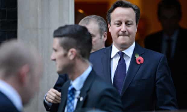 David Cameron, wearing poppy in his lapel and biting his lip, leaves Downing Street