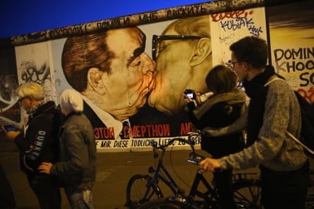 Visitors gather at a mural on the Berlin Wall