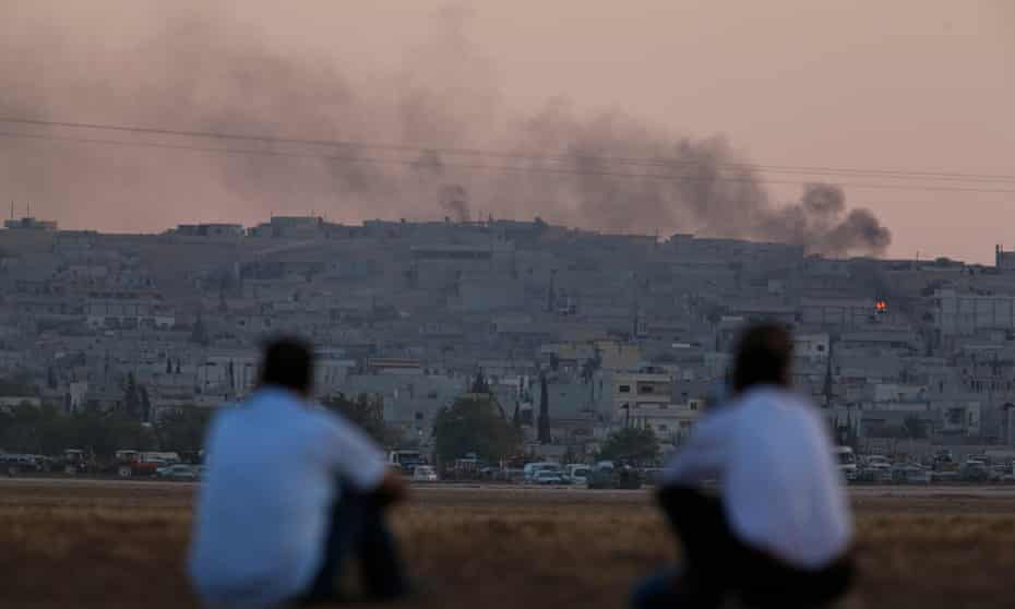 Turkish Kurds on the Turkey-Syria border watch the aftermath of air strikes on Kobani