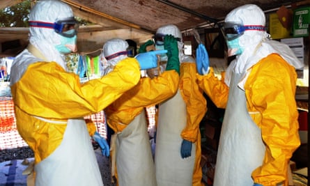 Health workers in Guinea, where the outbreak started, wear protective suits at Donka hospital in Conakry.