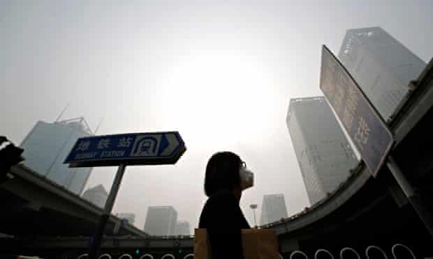 A woman wears a mask against heavy smog in Beijing