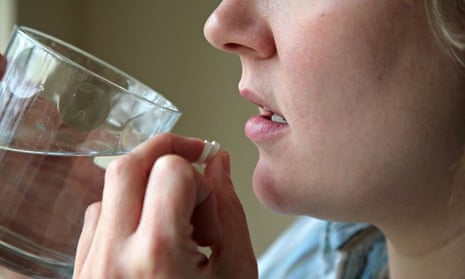 Woman taking pills and water