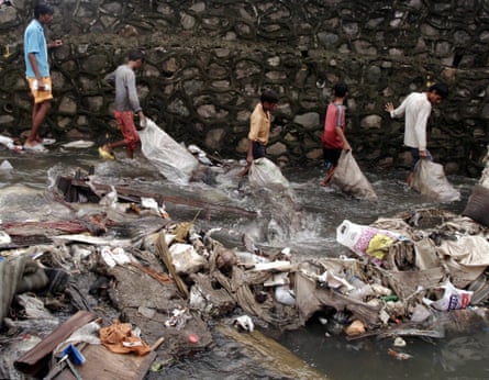 Indian slum-dwellers hunt for valuables in debris washed away by floods in Mumbai on July 30, 2005.