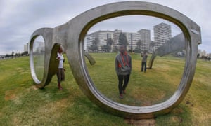 A man inspects a giant pair of Ray-Ban glasses, which are a public art tribute to Nelson Mandela, commissioned for the Sea Point seafront.