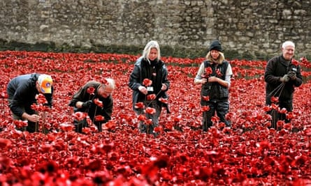 Volunteers remove poppies from the moat of the Tower of London