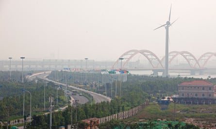 Wind turbines stand at the entrance to the Sino-Singapore Tianjin Eco-city in the Binhai New Area of Tianjin.