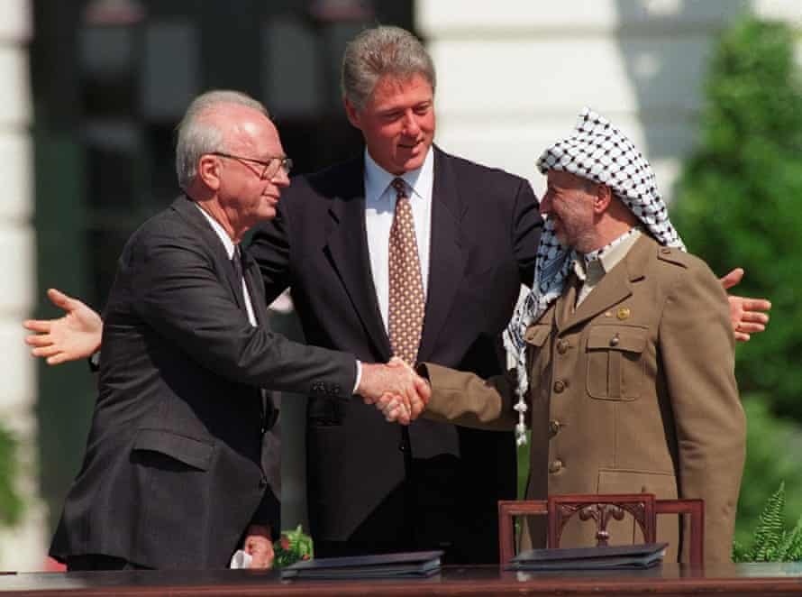 Yasser Arafat shakes hands with Israeli prime minister Yitzhak Rabin, watched by US president Bill Clinton, after the signing of the Oslo peace accord, in Washington in 1993.