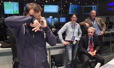 Rosetta's flight director, Andrea Accomazzo,, left,  takes a call after receiving confirmation that the Philae lander had successfully touched down.