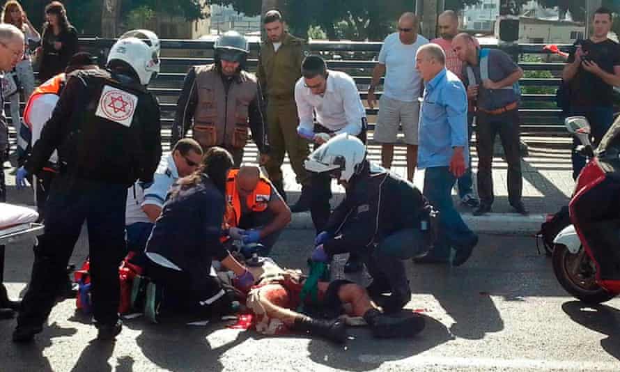 Israeli medics treat a wounded soldier at the scene of a stabbing attack in Tel Aviv.