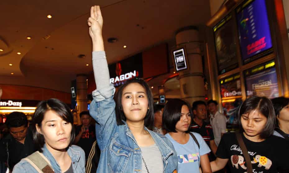 Pro-democracy activist Nacha Kong-udom is detained by female plain clothed police officers at a cinema in Bangkok on 20 November.
