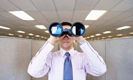 male office worker looking through binoculars