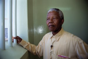 Nelson Mandela stands at the window of the cell in Robben Island Prison where he was incarcerated for more than two decades. 