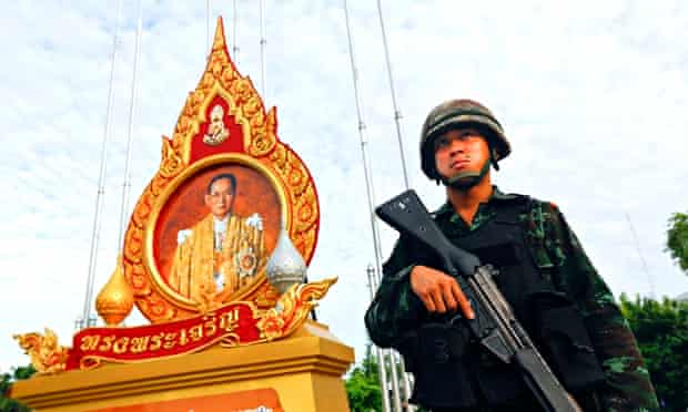 An Thai soldier beneath a portrait of King Bhumibol Adulyadej