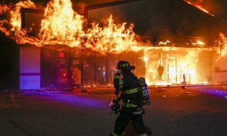 A firefighter arrives to inspect a pizza business set ablaze in Ferguson, Missouri.