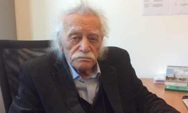 Manolis Glezos seduto ad una scrivania