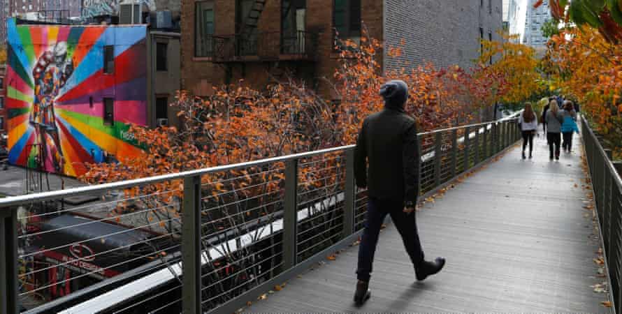 People walk along High Line park on a warm autumn day in New York