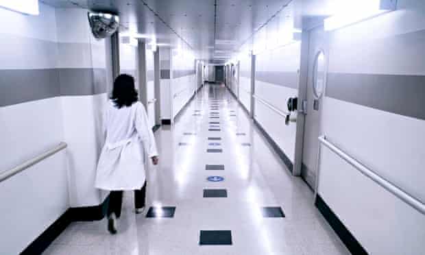 A clinician walks down a hospital corridor