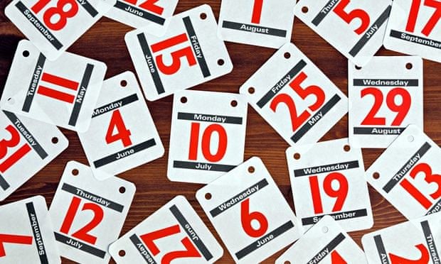 Photo of various calendar dates spread out on a wooden desk.