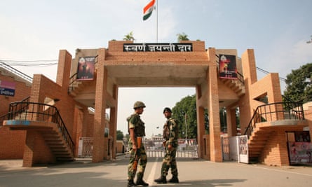 India's Border Security Force soldiers patrol in front of the golden jubilee gate at the Wagah border.