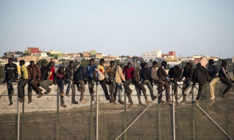 Would-be immigrants on a fence separating Morocco from the north African Spanish enclave of Melilla.