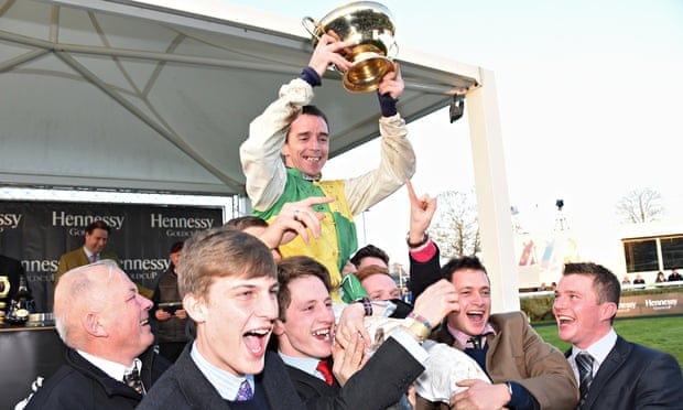 Leighton Aspell holding the Hennessy Gold Cup after his triumph aboard Many Clouds at Newbury