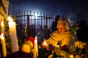 An elderly woman visits the grave of dead relatives, lighting candles, incense and decorating their graves in San Andre de Mixquic. All Photographs: Antonio Zazueta Olmos
