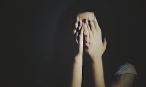 Young woman covering her face in the darkness
