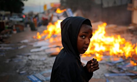 Boy walks past fire keeping evicted families warm
