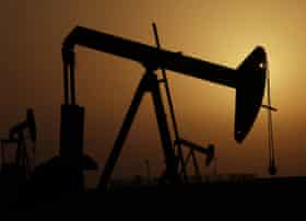 Oil pumps work at sunset in the desert oil fields of Sakhir, Bahrain, Tuesday, Oct. 14, 2014.